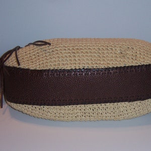 Może przedstawiać: Brązowa i beżowa pleciona torebka ze słomy z brązową sk&oacute;rzaną lam&oacute;wką i długim brązowym frędzlem.