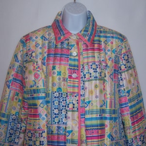 May include: A quilted jacket with a patchwork design in shades of pink, blue, yellow, and white. The jacket has a button-up front and a collar.