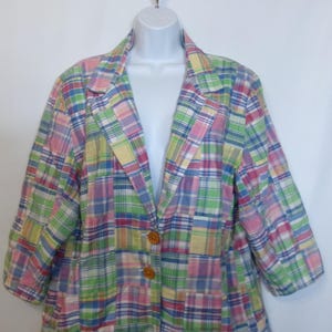 May include: A multi-colored plaid blazer with a patchwork design. The blazer features a pastel color palette of pink, green, blue, and yellow. It has two brown buttons and three-quarter sleeves. The garment is displayed on a white mannequin.