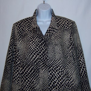 May include: A black and beige snakeskin patterned blazer. The blazer has a long sleeve and a v-neck collar.
