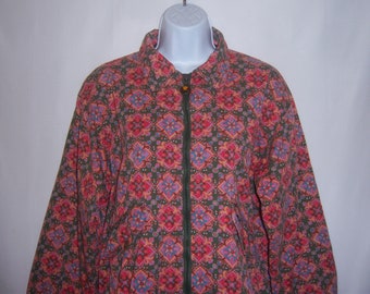 May include: A green, pink, and blue patterned jacket with a zipper closure. The jacket has a collar and long sleeves.
