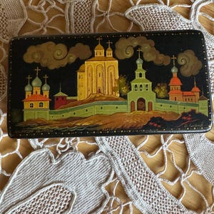 Caprichosa caja de laca negra rusa pintada a mano de edificios históricos raros
