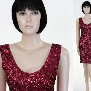 May include: A sleeveless sequined dress in a deep burgundy color. The dress has a V-neckline and a fitted silhouette.