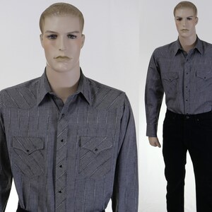 May include: A gray and white striped long-sleeve shirt with a button-down collar and two chest pockets. The shirt has a Western-style design with stitching details.