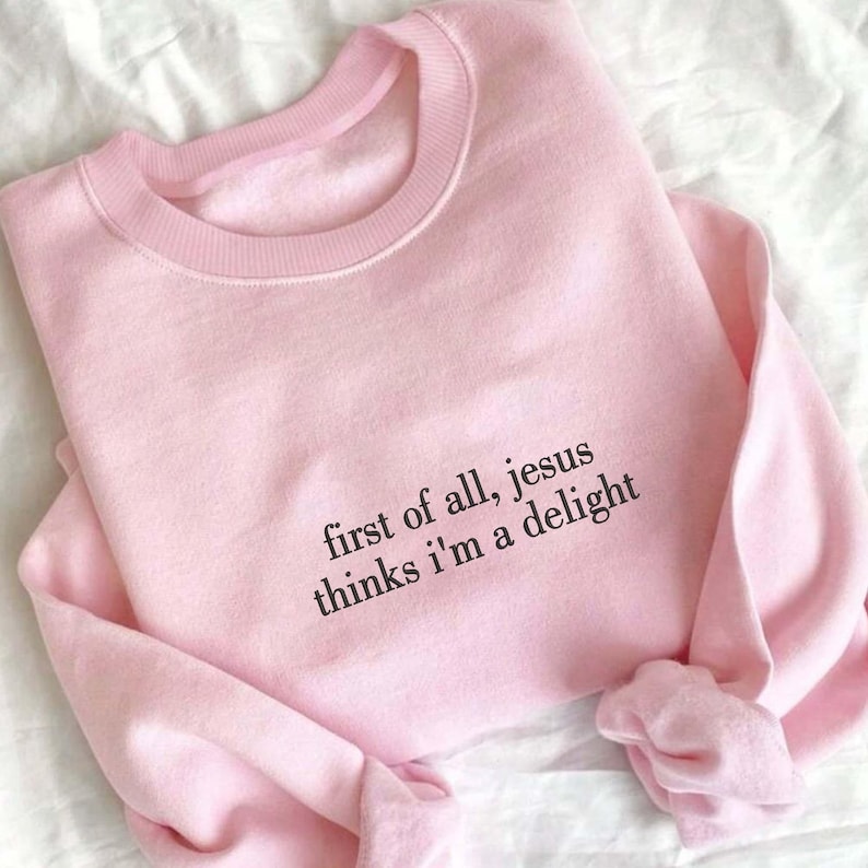 Pu&ograve; includere: Felpa rosa chiaro con la scritta nera "first of all, jesus thinks i'm a delight". La felpa &egrave; realizzata in materiale morbido e ha uno scollo tondo.