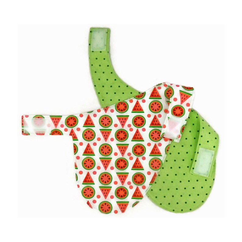 May include: A reversible dog bandana with a watermelon print on one side and green polka dots on the other side. The bandana has a velcro closure.