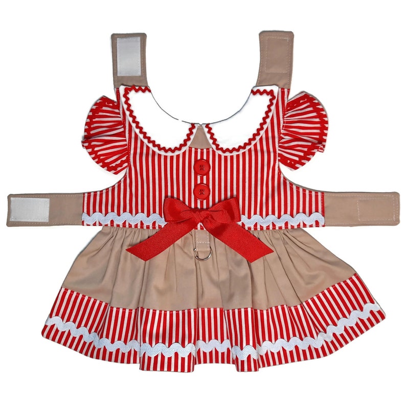 K&ouml;nnte beinhalten: Rotes und wei&szlig; gestreiftes Hundekleid mit braunem Rock, wei&szlig;em Kragen, roter Schleife und wei&szlig;em gewelltem Saum.