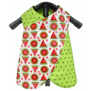 May include: A green and white sleeveless dress with a watermelon print. The dress has a criss-cross design at the neckline and a curved hem.