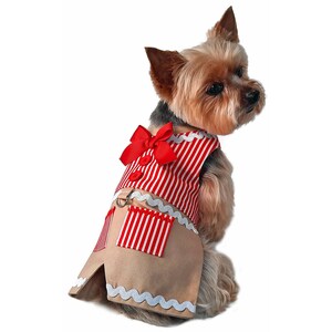 K&ouml;nnte beinhalten: Ein kleiner Hund, der ein rot-wei&szlig; gestreiftes Kleid mit einer roten Schleife tr&auml;gt. Das Kleid hat einen braunen Rock mit wei&szlig;em Besatz und eine Tasche auf der Vorderseite.