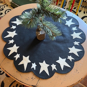 Star tree skirt measuring12 - 24 inches across with a black background and off white stars. Coffee dye stars available upon request.
