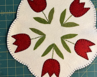 Tulip candle mat with an off white background and red tulips.