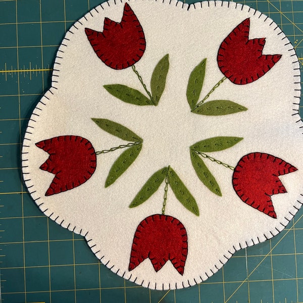 Tulip candle mat with an off white background and red tulips.