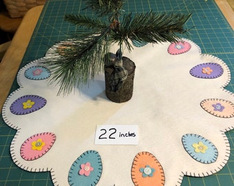 Easter egg tree skirt (hole in center) measuring 24 inches off white background with pastel eggs in the scallops.
