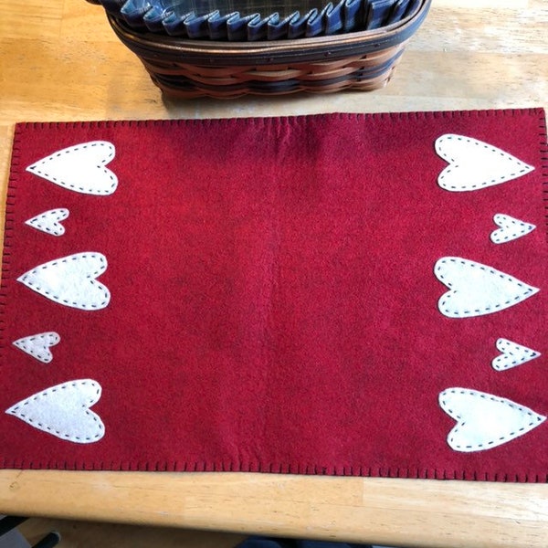 Wool felt primitive Valentine runner with a red background and off white hearts.