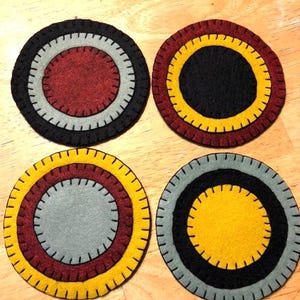 Wool felt blend penny coasters in red, green,gold and black.