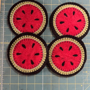 Primitive watermelon coasters set of 4 with a black background measuring about 5 inches.