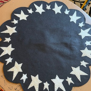 Star candle mat/table mat measuring 12-24 inches across(shown ) with a black background and off white stars. Other widths available.