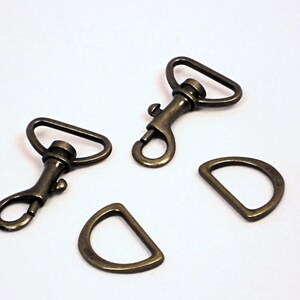 May include: Three antique gold-toned metal clasps, two are swivel clasps and one is a D-ring.