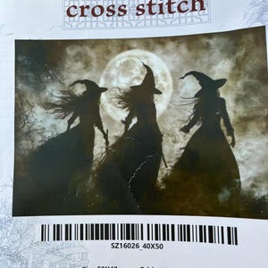 May include: Cross stitch kit depicting three witch silhouettes against a full moon. The kit includes the text "cross stitch", the size 50x40cm, and the grid count 196x153. The image has a barcode and the text "SZ16026 40X50".