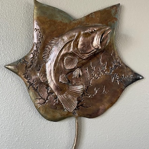 Forellenbarsch auf einem abgebildeten Tulpenbaumblatt in bronze