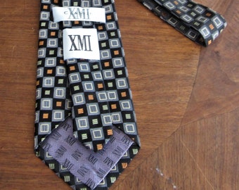 1970s 100% Silk Neck Tie with a gemetric print in black and grey with light ornge and olive green accents