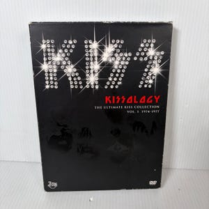 May include: Black DVD case for Kissology: The Ultimate Kiss Collection Vol. 1 1974-1977. The title "KISS" is in a sparkling, diamond-like font. The word "Kissology" is in red, with the DVD logo in the bottom right corner.