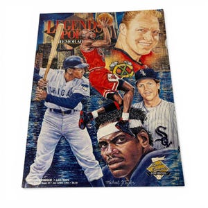 Può includere: Una copertina del programma Legends Pok Memorabilia con illustrazioni di giocatori di baseball e basket. La copertina include il testo "OFFICIAL PROGRAM 14th NSCC" e "Michael J. Taylor". Lo sfondo è un paesaggio urbano con un effetto acqua blu e bianco.