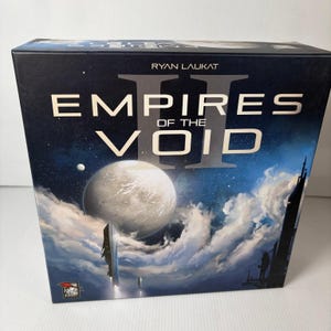Puede incluir: Una caja de juego de mesa titulada "Empires of the Void II" de Ryan Laukat. La caja presenta una ilustración con temática espacial con un planeta grande, nubes y un cielo estrellado. La caja es azul oscuro con letras blancas y plateadas.