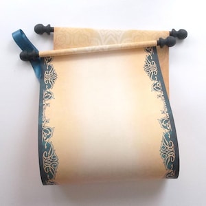 May include: A paper scroll with a light tan center and dark teal decorative borders featuring intricate swirling patterns. The scroll is attached to two wooden rods with black finials at each end and includes a teal ribbon accent on the left side.