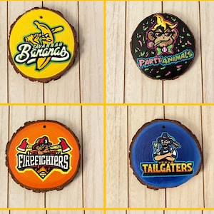 May include: A collection of six wooden ornaments with various team logos and text. The logos include a banana with the text "Savannah Bananas", a monkey with "Party Animals", a firefighter with "Firefighters", a baseball player with "Tailgaters", a baseball player with "Loco Beach Coconuts", and a clown with "Indianapolis Clowns".