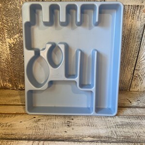 Pode incluir: Uma bandeja de talheres de pl&aacute;stico azul claro com compartimentos para garfos, facas, colheres e outros utens&iacute;lios. A bandeja &eacute; retangular com uma s&eacute;rie de divis&oacute;rias para manter os itens organizados. Ideal para uma gaveta de cozinha.