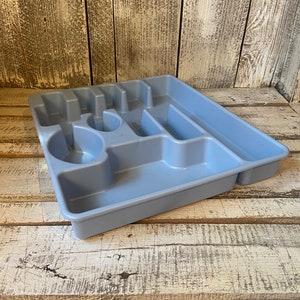 Pode incluir: Uma bandeja de talheres de pl&aacute;stico azul claro com v&aacute;rios compartimentos para organizar a prataria. A bandeja tem sec&ccedil;&otilde;es para garfos, facas, colheres e outros utens&iacute;lios. A bandeja &eacute; feita de pl&aacute;stico dur&aacute;vel e foi concebida para caber dentro de uma gaveta de cozinha.