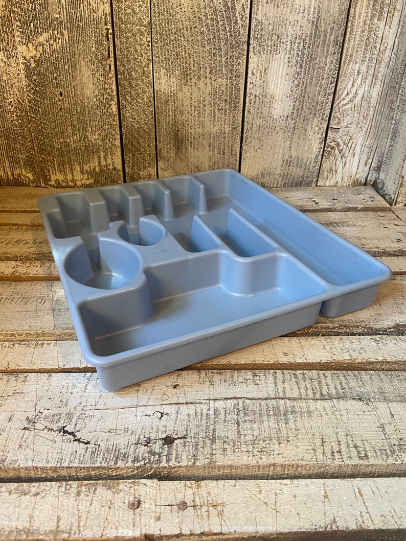 Pode incluir: Uma bandeja de talheres de pl&aacute;stico azul claro com v&aacute;rios compartimentos para organizar a prataria. A bandeja tem sec&ccedil;&otilde;es para garfos, facas, colheres e outros utens&iacute;lios. A bandeja &eacute; feita de pl&aacute;stico dur&aacute;vel e foi concebida para caber dentro de uma gaveta de cozinha.