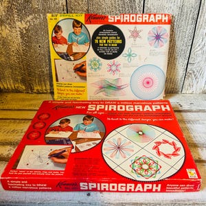 May include: Two vintage Spirograph kits. The top kit is yellow and white, labeled "New Refill Kit." The bottom kit is red, with the Spirograph logo. Both kits feature illustrations of children using the Spirograph to create colorful geometric designs.