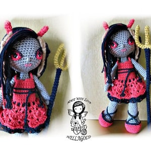 Puede incluir: Una muñeca de crochet vestida de diablo, con cuernos rojos, un vestido rojo y cabello negro. La muñeca sostiene un tridente dorado.