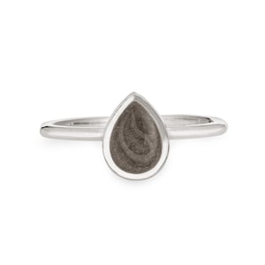 May include: A silver ring with a teardrop-shaped stone. The stone is a dark gray color and has a swirling pattern.