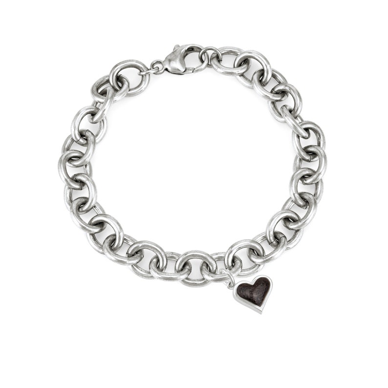 This photo shows the sterling silver cable chain cremation bracelet with the heart shaped ashes charm. The chain on this bracelet in thick and is a statement piece.