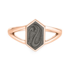 May include: A rose gold ring with a hexagonal gray stone. The stone has a swirling pattern.