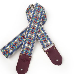 The Lefty Guitar Strap - Southwest style Native embroidered design in yellow, orange, red, white on  blue background with leather ends