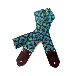 Sangle de guitare Pandora - Bleu sarcelle pourpre avec des reflets jaunes sur fond noir avec du cuir, du chanvre ou du nylon avec des détails en forme de cœur en diamant