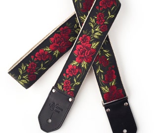 Le bracelet de guitare Buckley - Floral rouge et vert sur fond noir avec des extrémités en cuir personnalisées en noir pour guitares électriques, acoustiques, basses