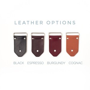 May include: Four leather strap end pieces in black, espresso, burgundy, and cognac colors. The strap ends are made of leather and have a metal buckle. The text "LEATHER OPTIONS" is above the strap ends. The text "BLACK", "ESPRESSO", "BURGUNDY", and "COGNAC" are below the strap ends.