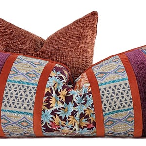 May include: A long, rectangular pillow with a patchwork design. The pillow is made of different fabrics, including velvet, paisley, and floral prints. The pillow is a mix of orange, purple, blue, and green colors.