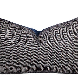 May include: A blue and white patterned throw pillow with a herringbone design. The pillow is filled with a soft, comfortable material.