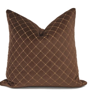May include: A brown velvet pillow with a diamond pattern stitched in gold thread.