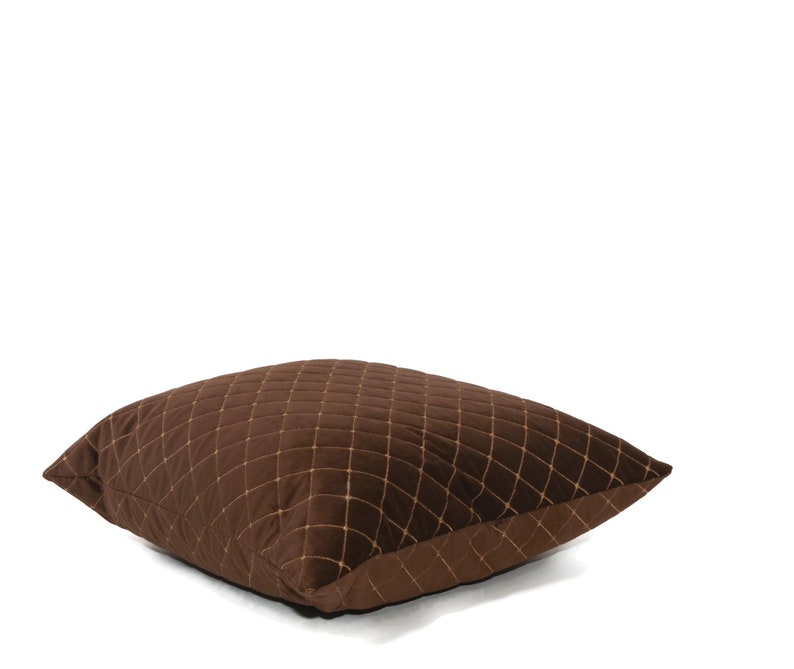 May include: A brown quilted throw pillow with a diamond pattern. The pillow is made of a soft, plush fabric and has a subtle sheen.