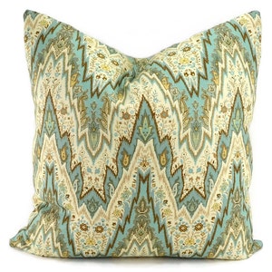 May include: A decorative throw pillow with a teal, brown, and cream patterned design. The pattern features a paisley-like design with a chevron background.