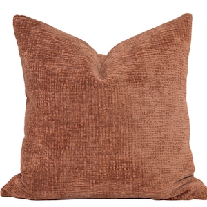 May include: A brown textured throw pillow with a square shape.