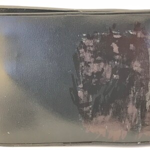 May include: A black leather wallet with a faded, abstract design on the front.
