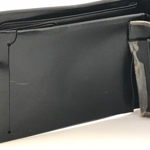 May include: A black leather wallet with multiple compartments and folds. The wallet is open and the inside is visible.